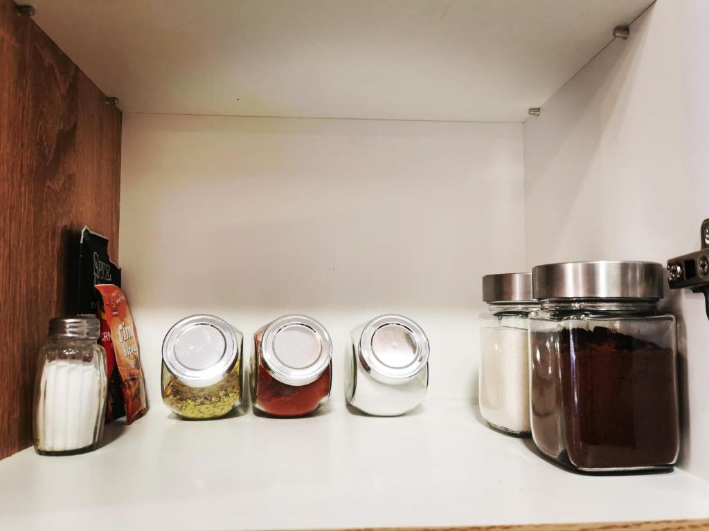 a kitchen counter with four jars of food at Gold Apartman in Subotica