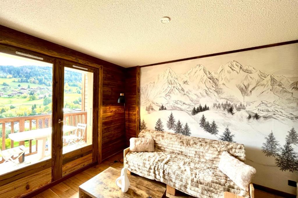 a living room with a mountain mural on the wall at Les Cimes Blanches in Combloux
