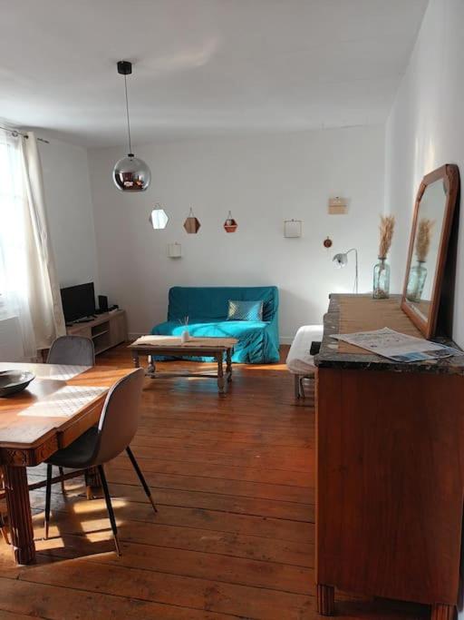 un salon avec une table et un canapé bleu dans l'établissement Charmant T2 place de Verdun, à La Rochelle