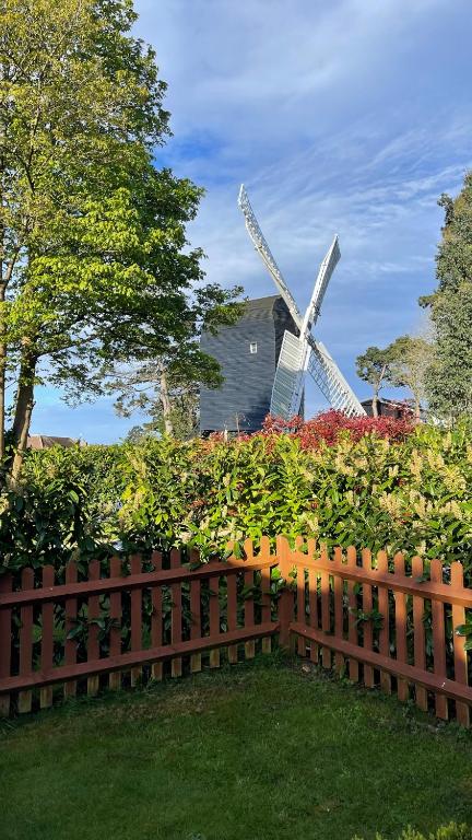 a wooden fence with a windmill in the background at Windmill Cottage in Worthing