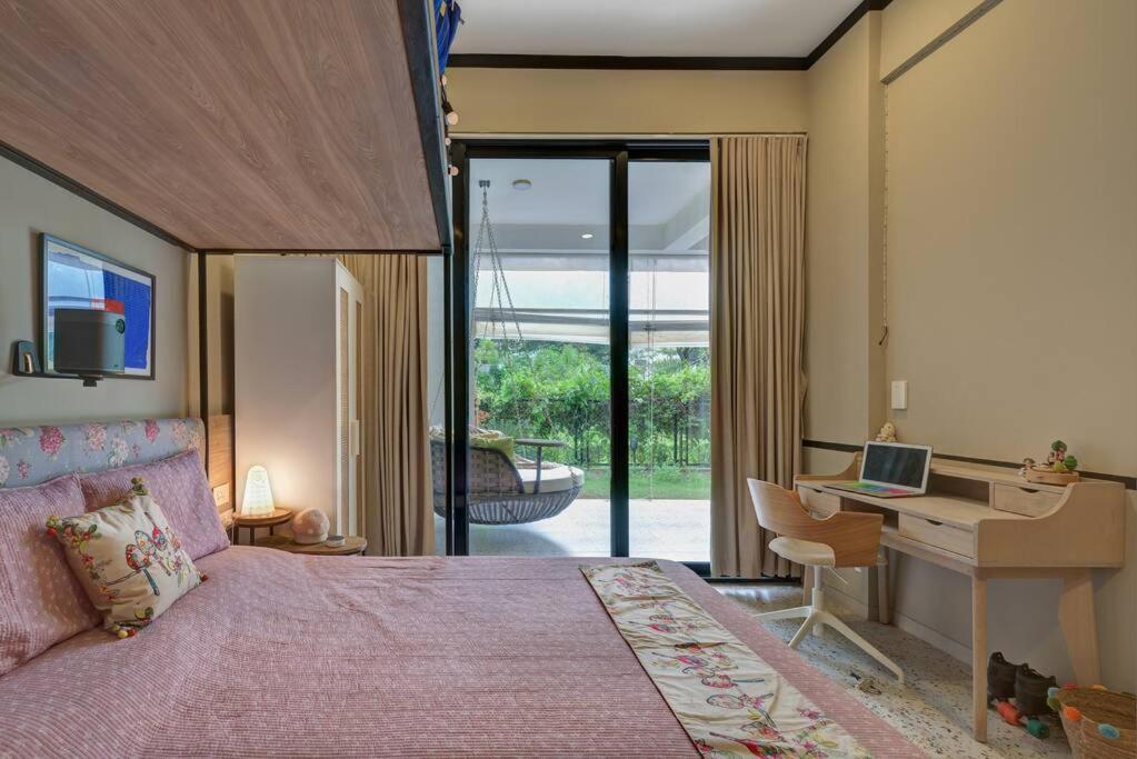 a bedroom with a bed and a desk with a computer at Tranquil Alibaug in Alibag