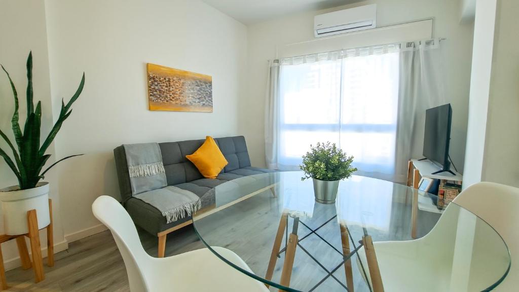 a living room with a couch and a glass table at Moderno piso 10! Garage! River - ViaVivaChino in Buenos Aires