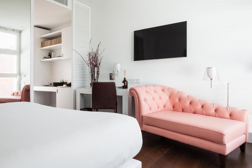 A television and/or entertainment centre at Magna Pars l'Hotel à Parfum, Small Luxury Hotels of the World