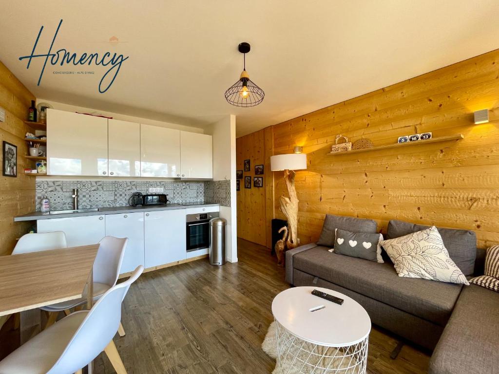un salon avec un canapé et une table dans l'établissement Homency - Résidence Les Gémeaux I3, à L'Alpe-d'Huez