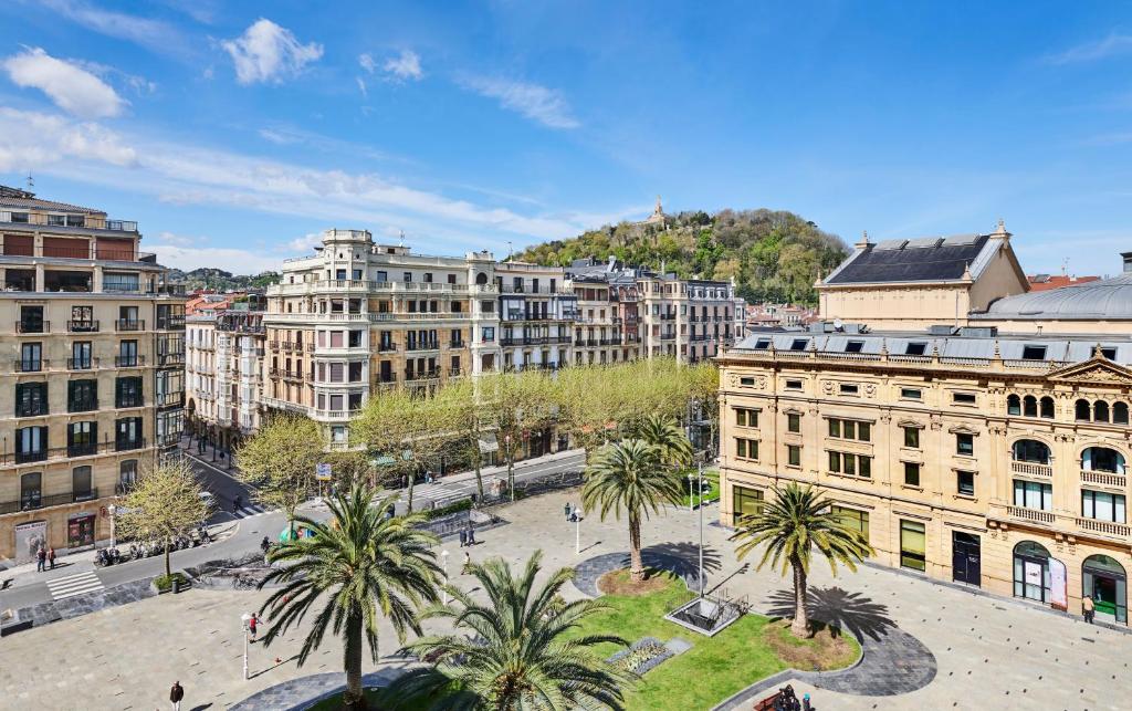 a view of a city with palm trees and buildings at Hotel Maria Cristina, a Luxury Collection Hotel, San Sebastian in Donostia-San Sebastián