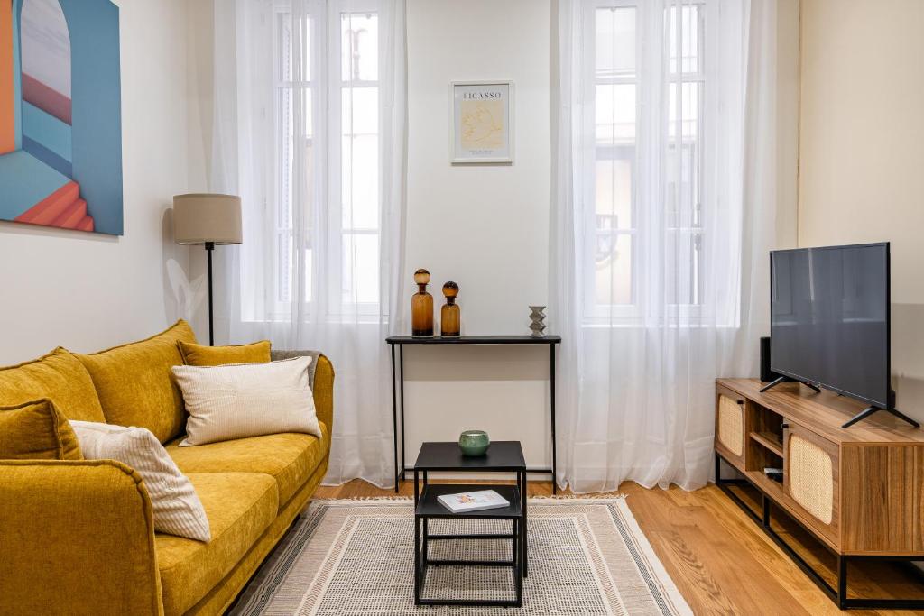 エクス・アン・プロヴァンスにあるSuite cosy dans le centre historiqueのリビングルーム(黄色のソファ、テレビ付)