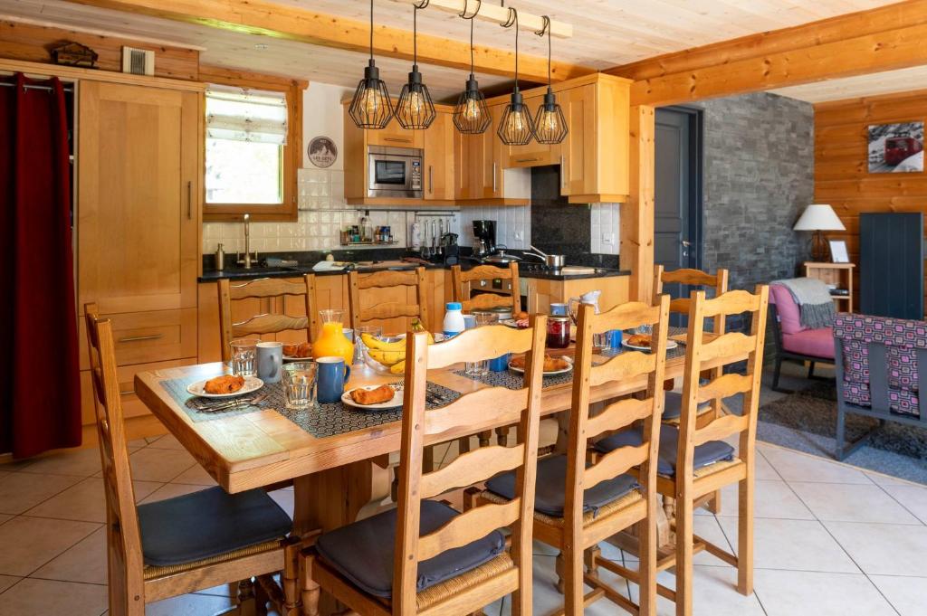 une cuisine et une salle à manger avec une table et des chaises en bois dans l'établissement Chalet Olaf, aux Gets