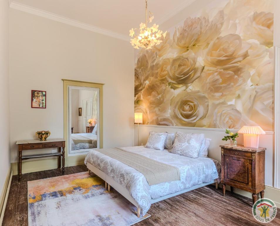 une chambre avec un lit et un tableau au mur dans l'établissement Petite Maison de Famille de Charme en Vallée du Lot, à Lédat