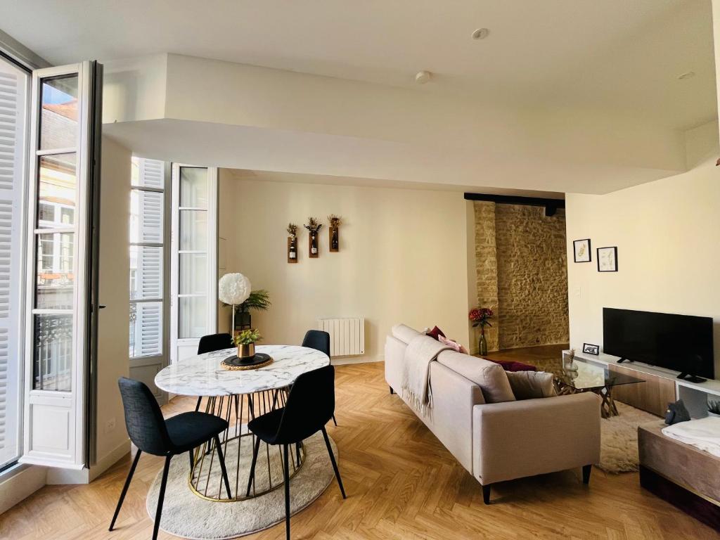 a living room with a couch and a table at Loft Pasteur - Homillesime in Dijon