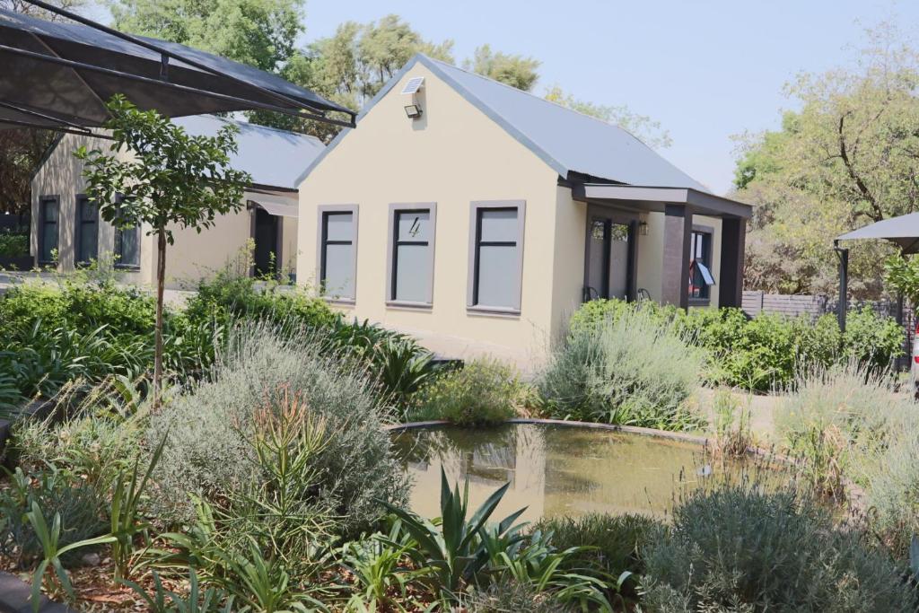 a house with a pond in front of it at Febe-Mari Guesthouse in Zeerust