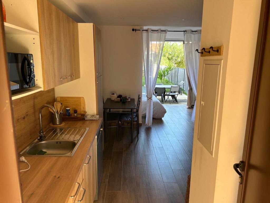 - une cuisine avec un évier et une table dans une chambre dans l'établissement Magnifique appartement en bord de mer, à Borgo