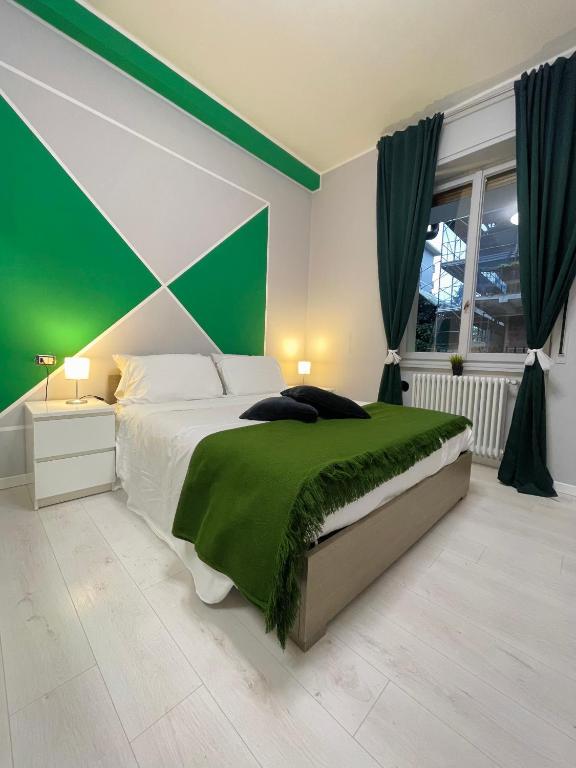 a bedroom with a bed with a green accent wall at 22CAP apartment in Milan