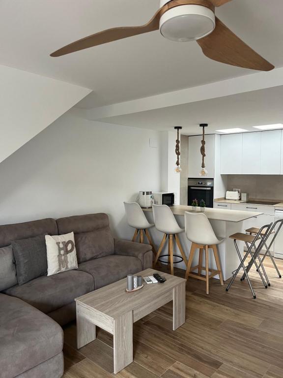 Una sala de estar con un sofá y un ventilador de techo. en Casita Sol y Mar, en Alicante