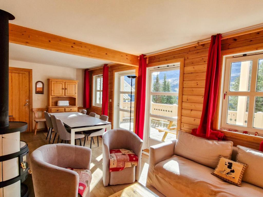 salon z czerwonymi zasłonami oraz stołem i krzesłami w obiekcie Chalet confortable avec poêle et terrasse, 3 chambres, garage, animaux admis - FR-1-425-198 w mieście Arâches-la-Frasse