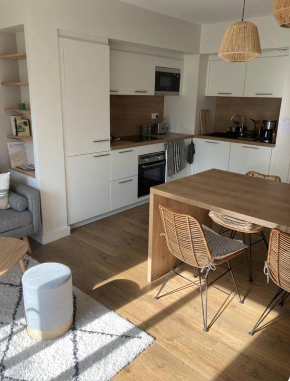 une cuisine avec une table et des chaises en bois dans l'établissement Appartement d'Exception à 20m de la Plage Votre Évasion Parfaite, à Saint-Brévin-les-Pins