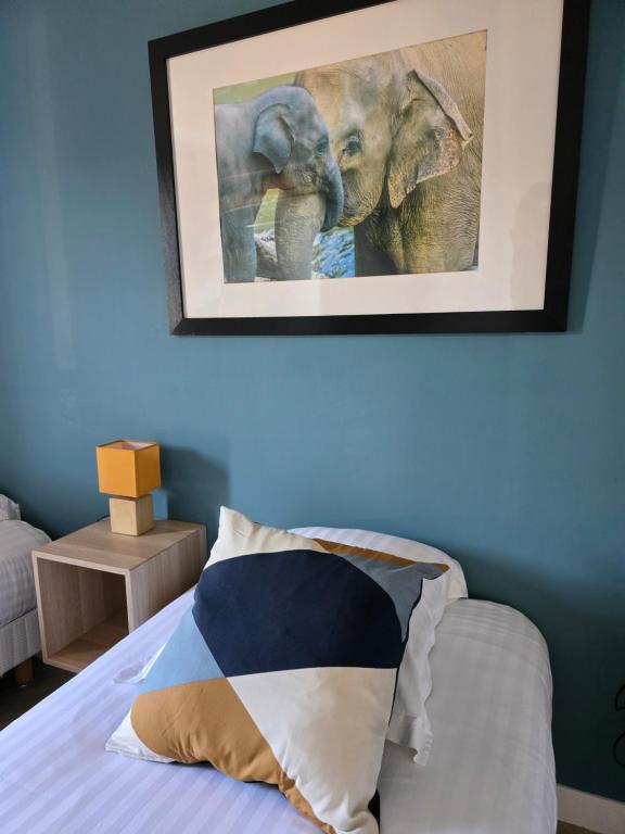 a bedroom with a bed with a picture of an elephant at Hôtel L'ideal le Mountbatten in Arromanches-les-Bains