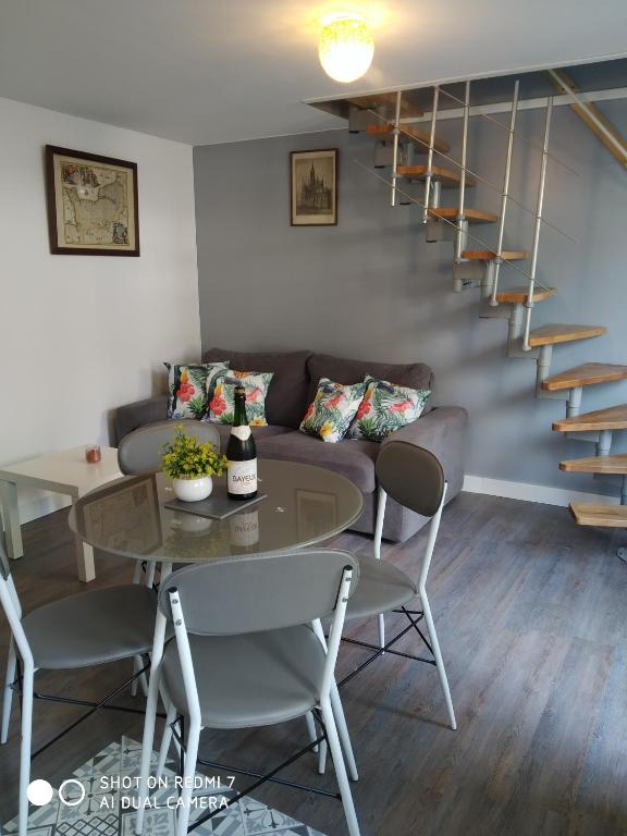 a living room with a couch and a table at Charmant petit logement in Bayeux