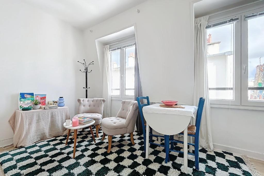 un salon avec une table et des chaises dans l'établissement Cozy Studio in the Heart of Oberkampf, à Paris