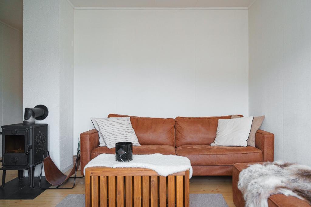 a living room with a brown couch and a wood stove at Arctic Apartment Heart of Tromsø in Tromsø