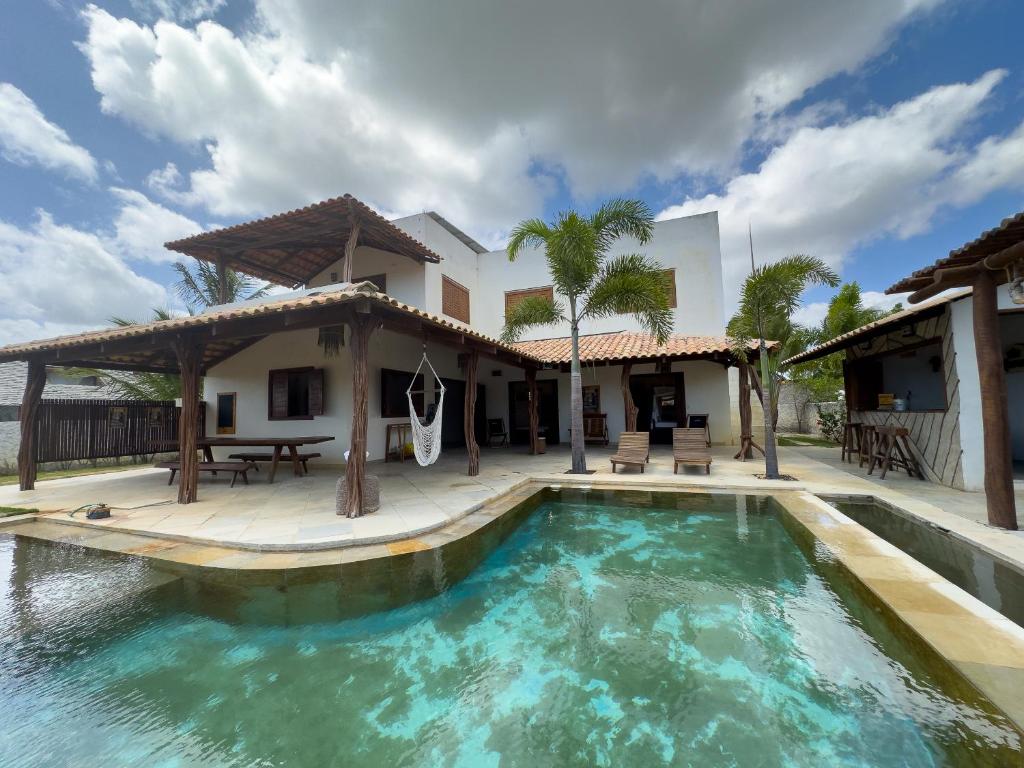 a house with a swimming pool and a patio at Exclusive House Preá in Cruz