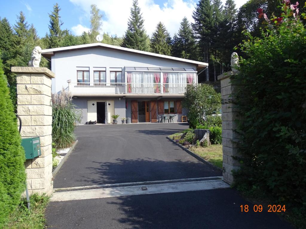 ein großes weißes Haus mit einer Auffahrt in der Unterkunft Profiter du calme de la montagne vosgienne in Saulxures-sur-Moselotte