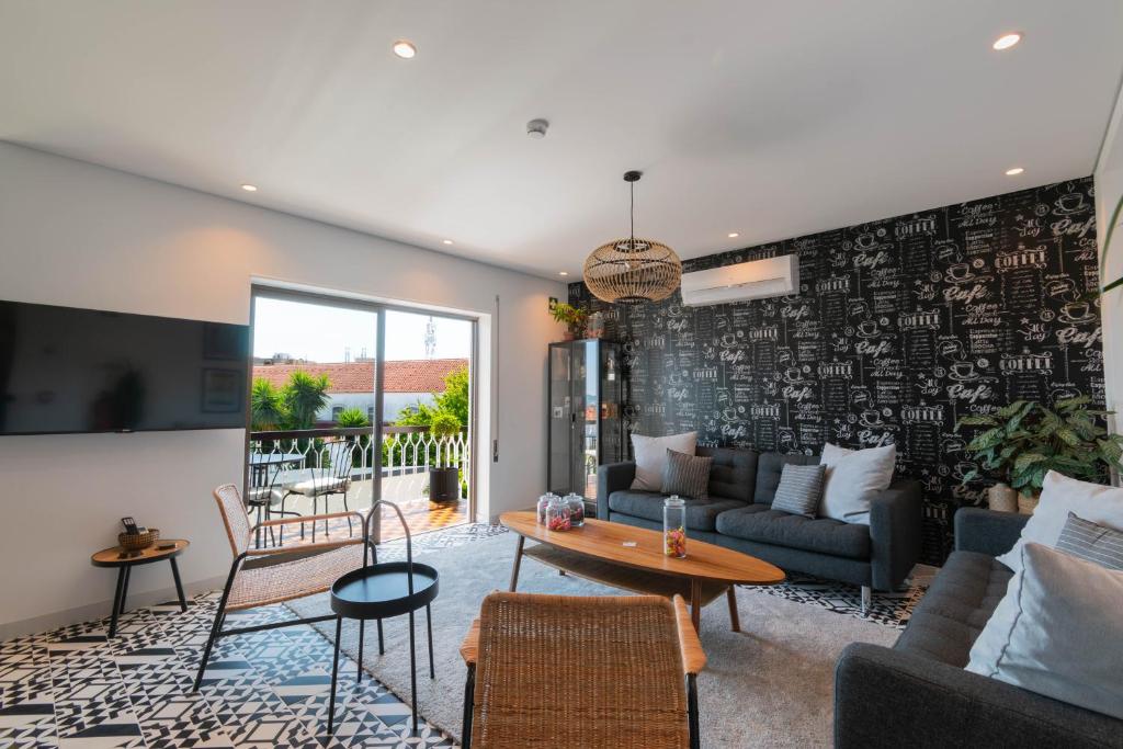 un salon avec un canapé et une table dans l'établissement 7Min to Uni Sé-Velha - AC - Work Desk - 300MBs WiFi - Suite 5, à Coimbra