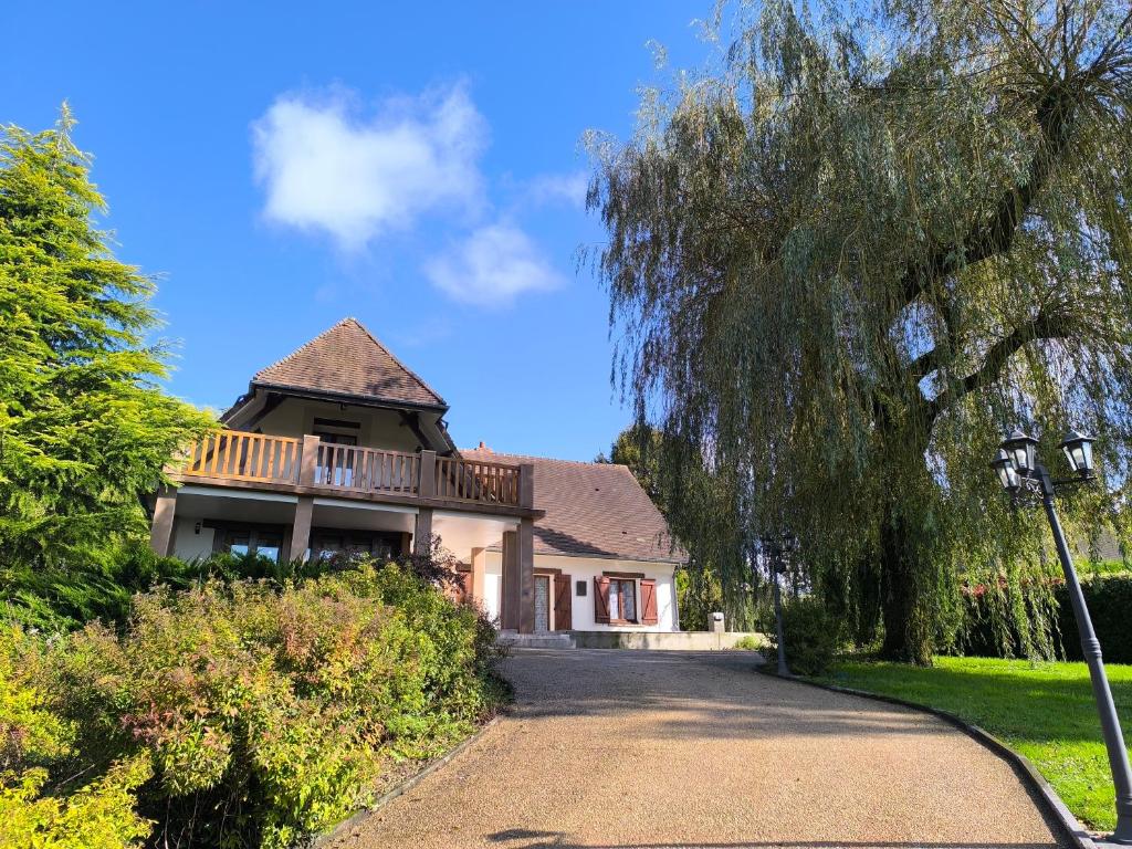 una casa con un porche y una terraza en un camino de entrada en Cocon familial verdoyant - Famille Only - Fête interdite, en Montreuil-aux-Lions