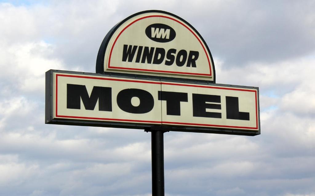 una señal para un motel en un poste en Windsor Motel, en New Windsor