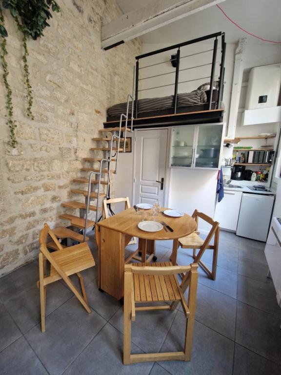 une salle à manger avec une table et des chaises et un escalier dans l'établissement Studio Marais Ménilmontant, à Paris