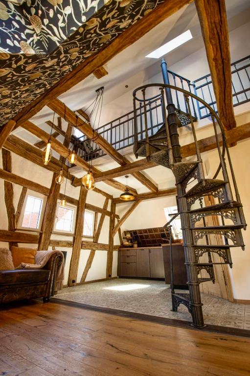 eine Wendeltreppe in einem Raum mit Holzbalken in der Unterkunft Maison Da Silva in Oberderdingen