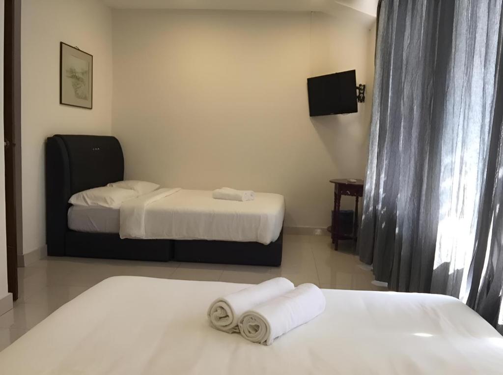 a room with two beds and two towels at FKI INTERNATIONAL HOTEL in Kuala Lumpur