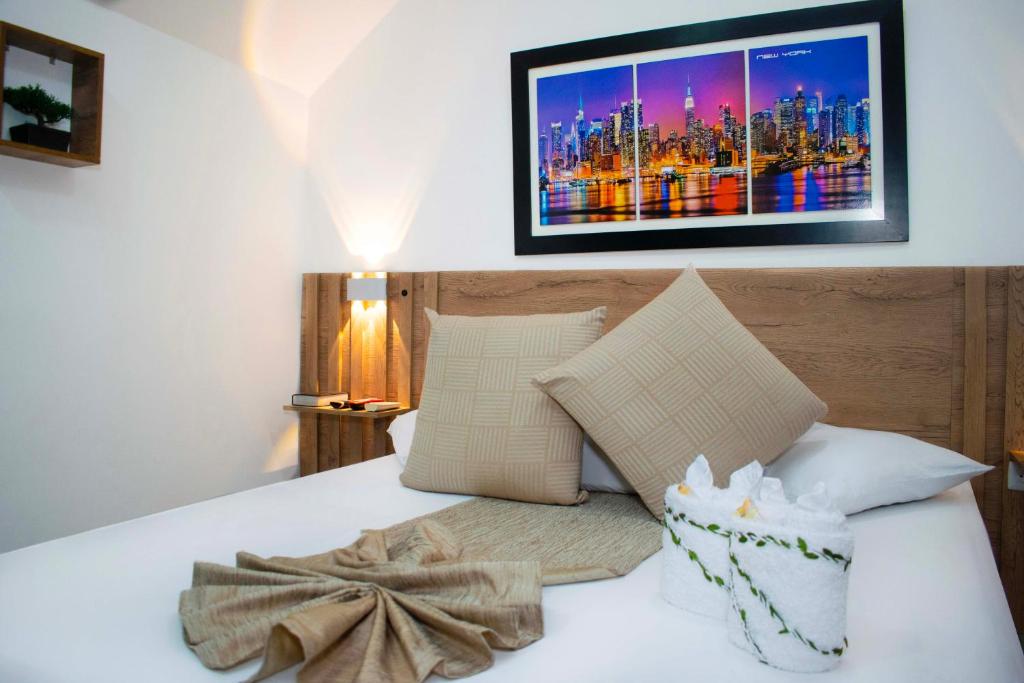 Un dormitorio con una cama con un cuadro en la pared. en Sixth House Suite, en Cali