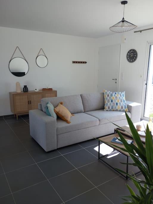 un salon blanc avec un canapé et une table dans l'établissement Maison 3 chambres 4 lits 6 personnes, à Challans