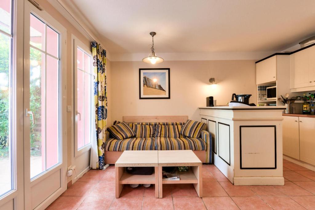 un salon avec un canapé et une table dans l'établissement Les Maisons de Lacanau les Pins - maeva Home - Maisons 3 pièces 6 personnes - Prestige MAE-4591, à Lacanau