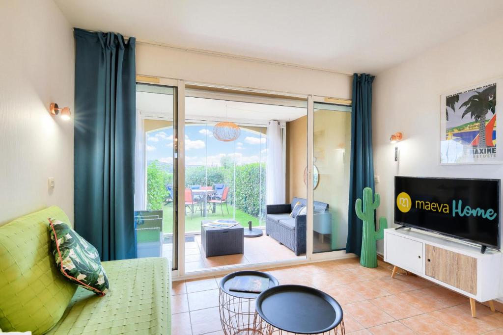un salon avec un canapé et une télévision dans l'établissement Résidence le Hameau des Issambres - maeva Home - Appartement avec jardin 2 pièces 4 personnes - Prestige - super Home MAE-4621, aux Issambres