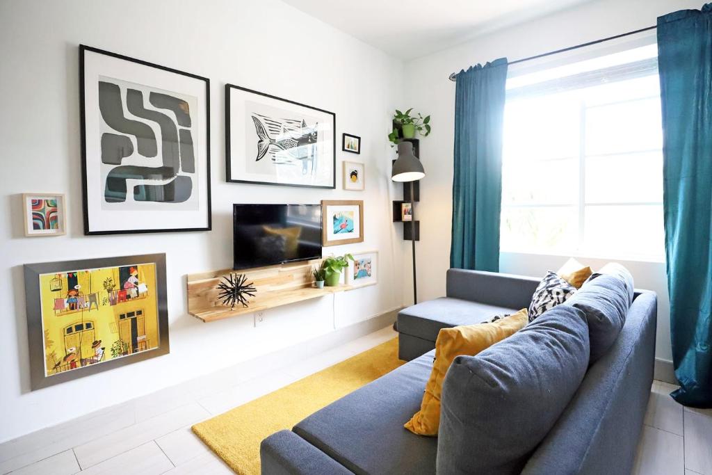 Una sala de estar con un sofá y un televisor. en 2 Bedroom Apartment 3 Minute Walk to South Beach & Ocean Drive, en Miami Beach