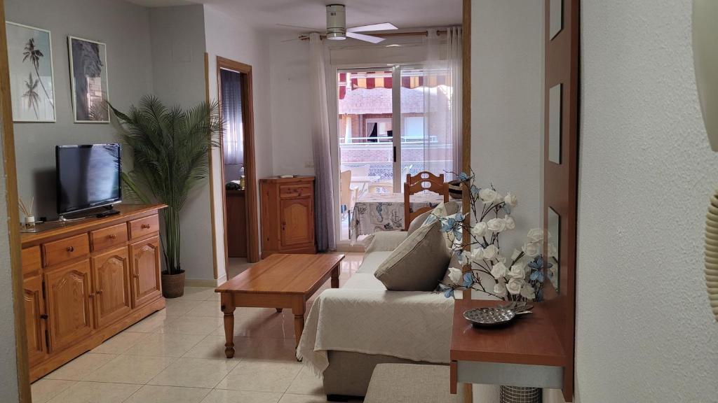 Una sala de estar con un sofá y un televisor. en Mediterráneo Gourmet Stays, en Oropesa del Mar