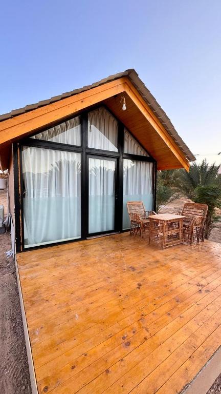 une grande terrasse en bois avec une table et des chaises dans l'établissement اكواخ العلا رقم 1, à Madain Saleh