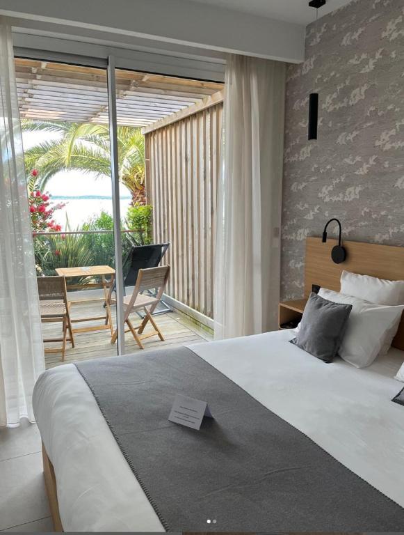 a bedroom with a large bed and a balcony at Hôtel L'Albatros in Saint-Trojan-les-Bains