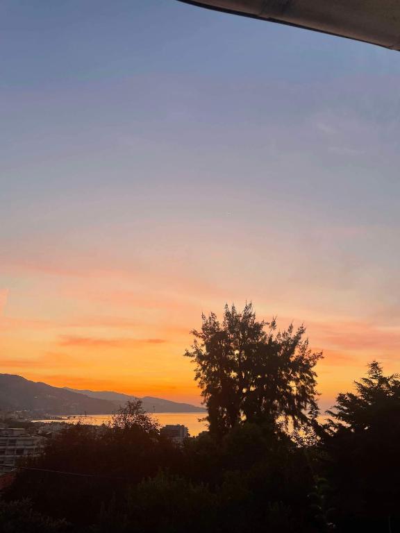- une vue sur le coucher du soleil depuis la fenêtre dans l'établissement Charming little house, sea view and big terrace, à Roquebrune-Cap-Martin