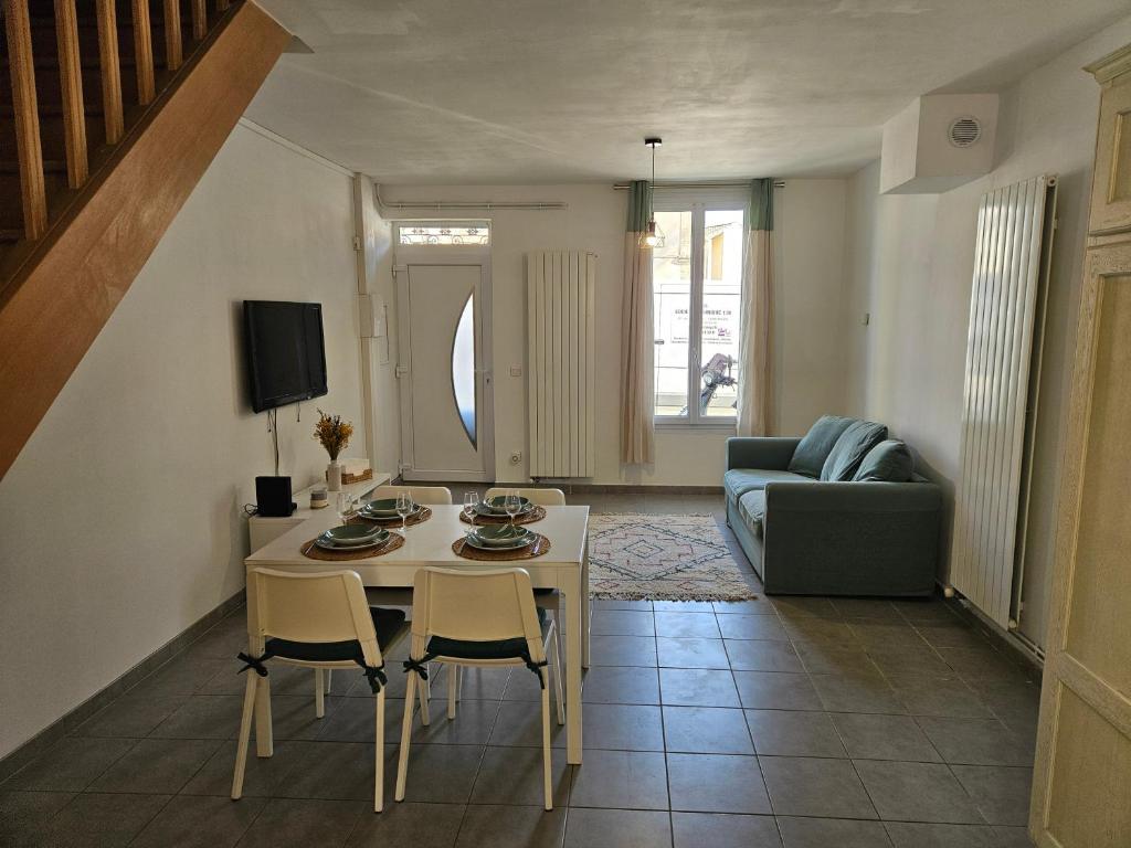 un salon avec une table, des chaises et un canapé dans l'établissement La Maison d'Alex, à Arles