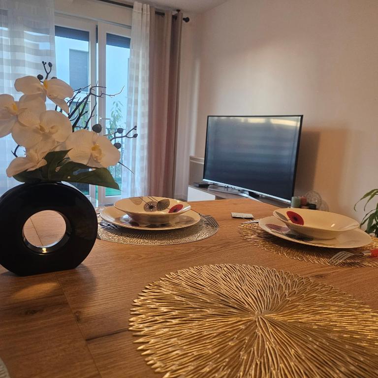 a wooden table with two plates and a vase of flowers at Casamia in Amiens