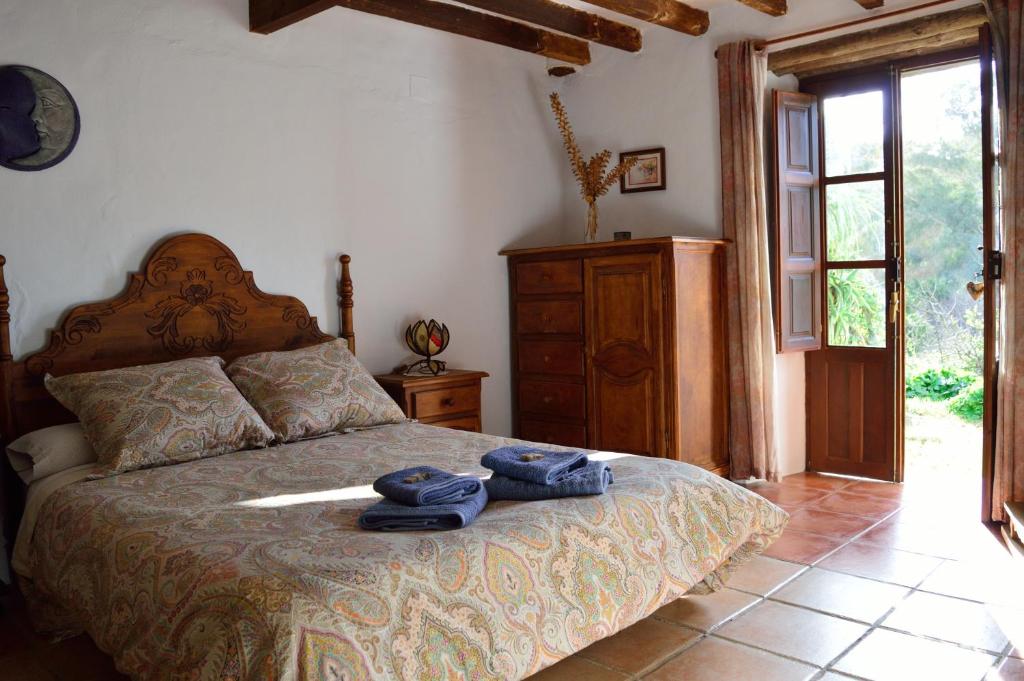 a bedroom with a bed with two towels on it at Casa Rural Ahoraya in El Colmenar