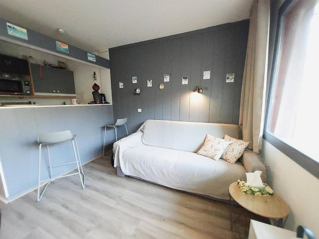 un salon avec un canapé blanc et une table dans l'établissement Résidence Camarine G - CAMARINE 24 MAE-7111, à Valmorel