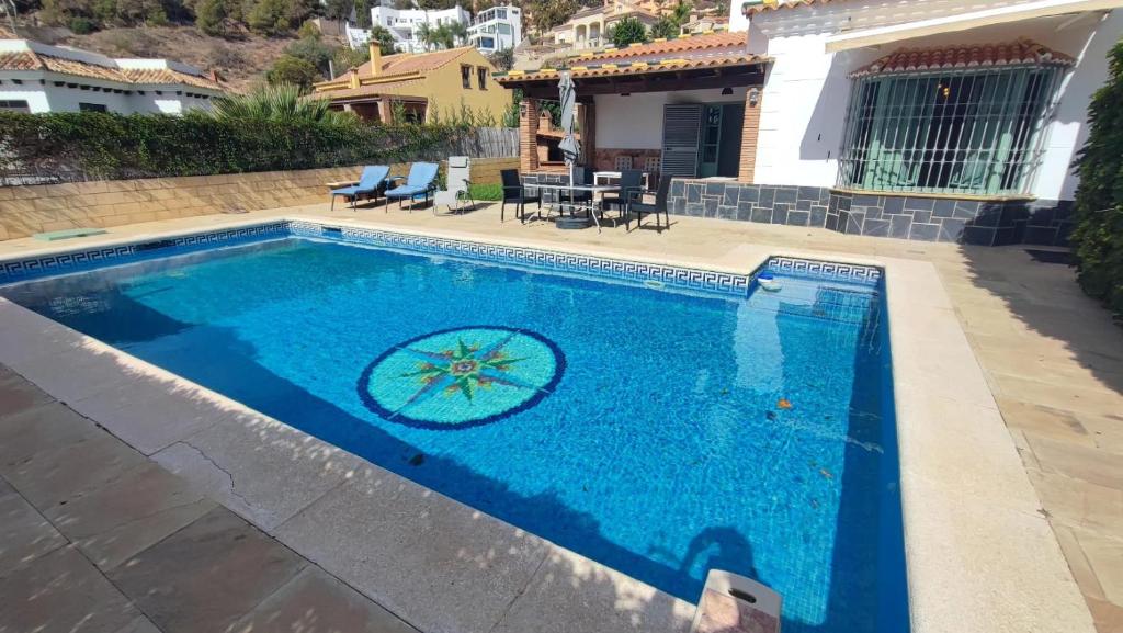a swimming pool in front of a house at Villa Arte de Aguilas in El Palo