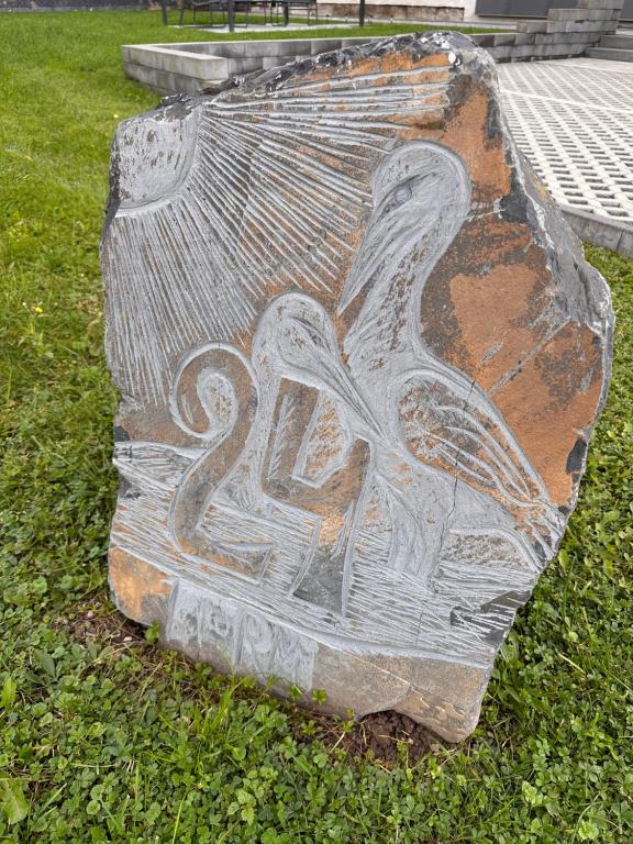 a stone statue of a pelican on the grass at Ferienwohnung Storchennest in Eisfeld