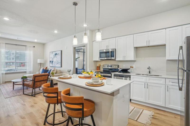 a kitchen with white cabinets and a kitchen island with chairs at New upscale community centrally located to Waco destinations in Lacy-Lakeview