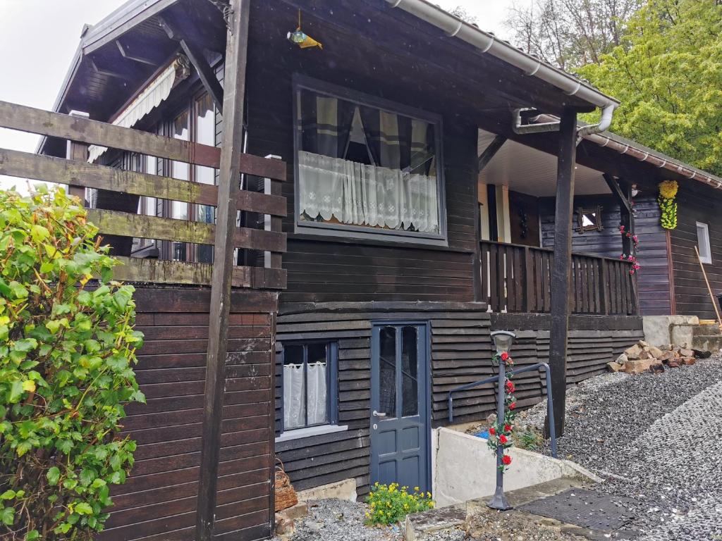 a wooden house with a blue door and a porch at Chalet Paradise Cottage in Hastière-par-delà