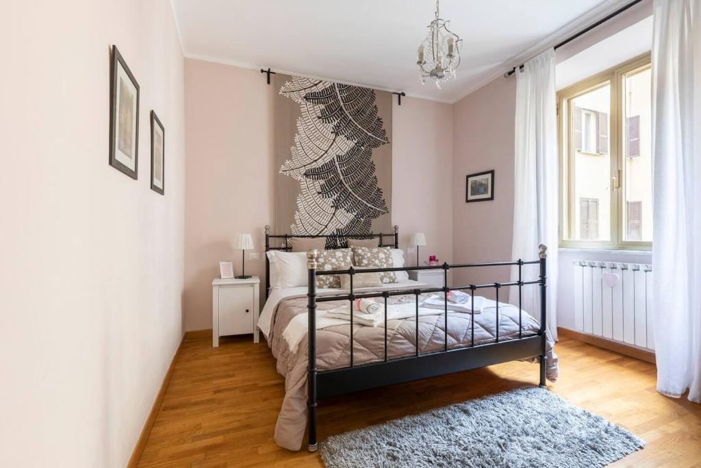 sypialnia z łóżkiem i żyrandolem w obiekcie Florje House w Rzymie