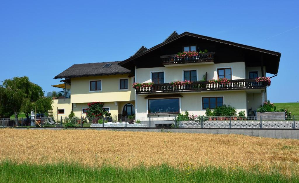 ein großes Haus mit Balkonen und Blumen darauf in der Unterkunft Haus Gruber in Attersee am Attersee